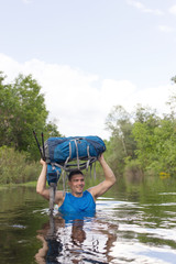 Man crossing the river with a backpack.
