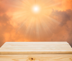 Wood table top with orange clouds and sunlight background