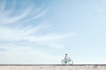 Girl enjoying bike ride under sky