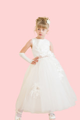 little girl in a ball gown isolated on a pink background