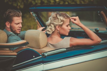 Wealthy couple in a classic convertible