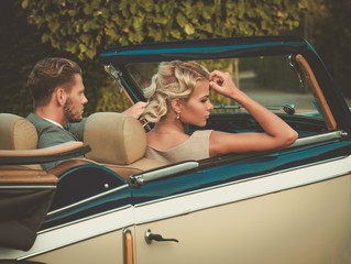 Fototapeta na wymiar Wealthy couple in a classic convertible