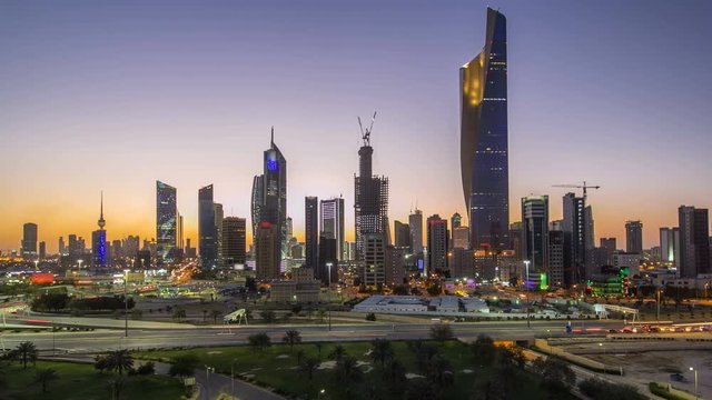 Skyline with Skyscrapers day to night timelapse in Kuwait City downtown illuminated at dusk. Kuwait City, Middle East
