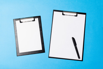 blank office objects organized for company presentation on blue paper background