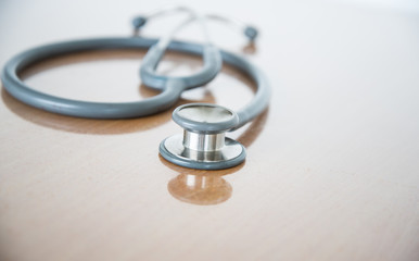 Fototapeta na wymiar Close up view of grey stethoscope on brown background.