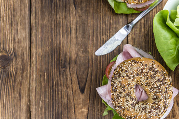 Wooden table with Ham Bagel (selective focus)
