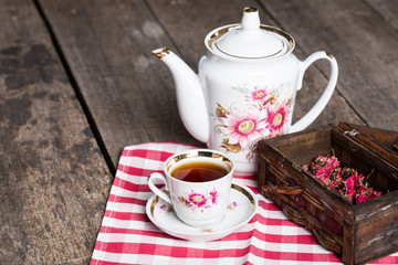 still life with tea cup and tablecloth on wooden table
