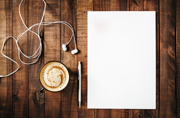 Blank branding template on vintage wooden table background. Blank white letterhead, pen, headphones...