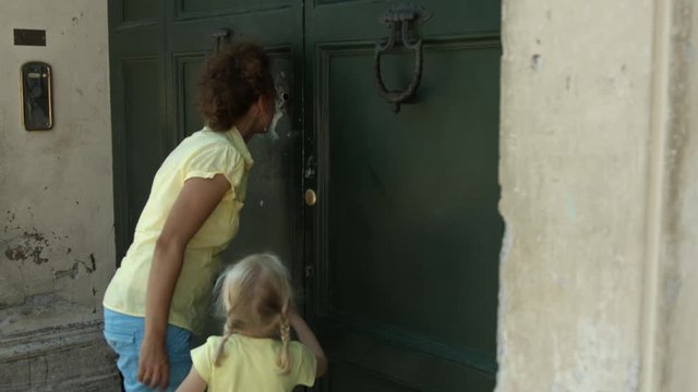 Mamma con bambina dai capelli biondi guarda nel buco della serratura la cupola di San Pietro  a Roma, Italia, Europa
