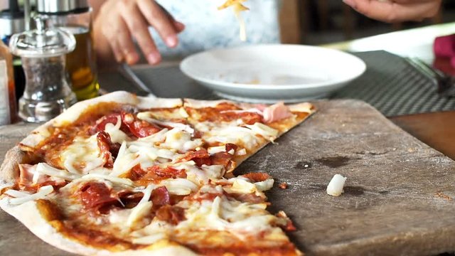 Woman hand take a pieces of pizza sliced.
