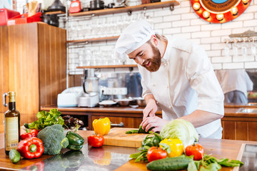 Chef cook making vegetable salad on the kitchen