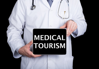 technology, internet and networking in medicine concept - Doctor holding a tablet pc with medical tourism sign. Internet technologies in medicine and tourism