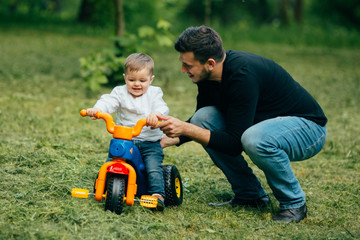 Fototapeta premium Father learn kid to ride a small bicycle in park.