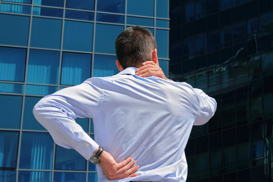 Man Rubbing His Painful Neck. Business Man With Back Pain. Pain Relief Concept