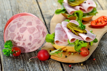 Garniertes Brötchen mit Bierschinken und Essiggurke  - Open faced sandwich with sliced ham sausage...