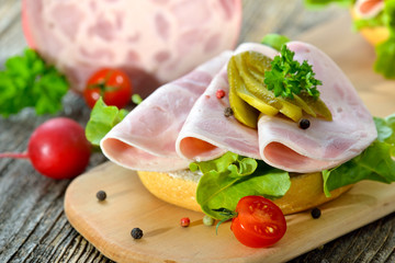 Garniertes Brötchen mit Bierschinken und Essiggurke  - Open faced sandwich with sliced ham sausage...