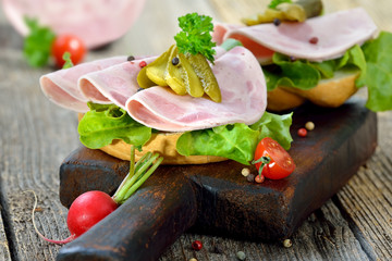 Garniertes Brötchen mit Bierschinken und Essiggurke  - Open faced sandwich with sliced ham sausage...