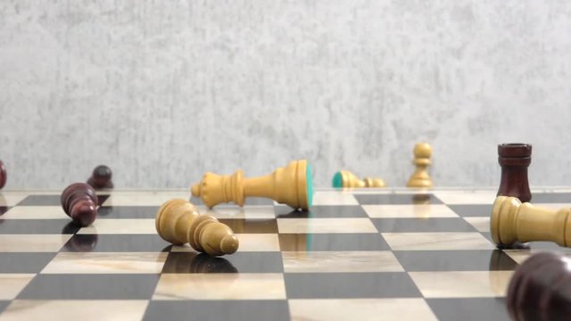Chess pieces falling down on chessboard in slow motion. Concept of disorder and confusion, commotion and chaos.
