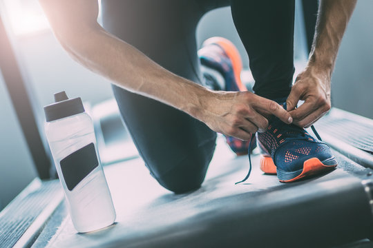 Portrait of a man tying shoelaces - Powered by Adobe