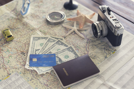 ship figurine, compass, passport, credit card, banknote,  camera
