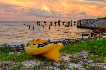 A beached yellow sea kayak on the beach at Fort Jefferson at sun