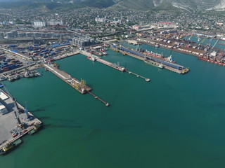 Obraz premium Industrial seaport, top view. Port cranes and cargo ships and barges.