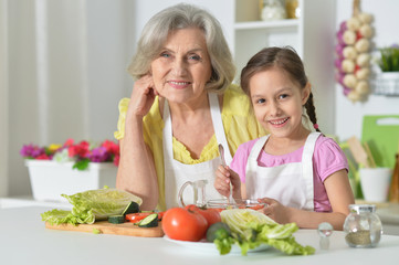 Obraz na płótnie Canvas Senior woman with granddaughter cooking
