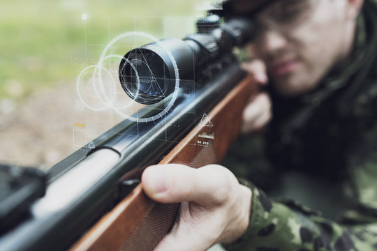 close up of soldier or sniper with gun in forest