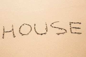 word house written in sand on beach