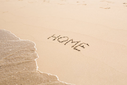 word home written in sand on beach