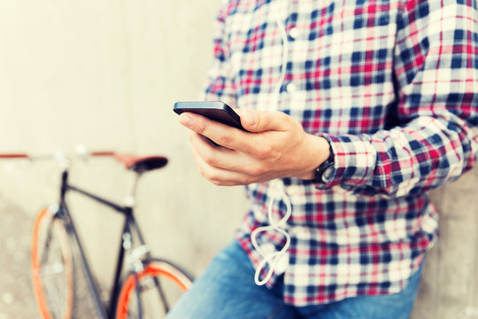 close up of hipster man with smartphone and bike