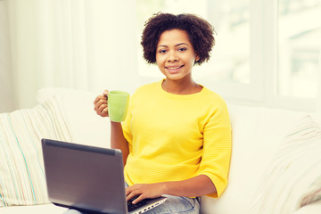 happy african american woman with laptop at home