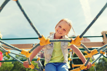 happy little girl climbing on children playground