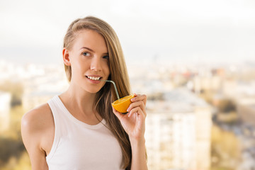 Woman drinking from orange