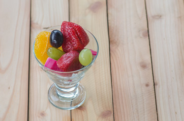 mixed fruit in glass on wood table, healthy food