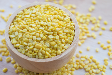Yellow millet grains in wooden bowl