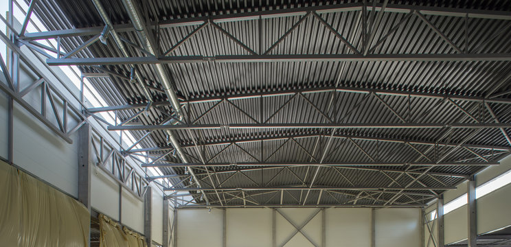 Metal roof inside the hangar. Large room with a tin roof.