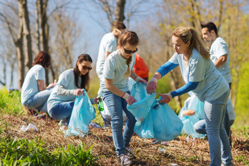 volunteers with garbage bags cleaning park area