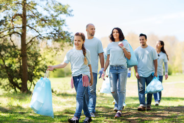 group of volunteers with garbage bags in park