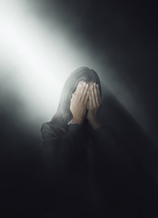 Young woman covering her face with her hands