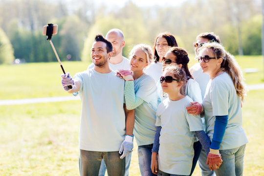 group of volunteers taking smartphone selfie