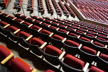Naklejka premium Folded red seats at a multipurpose arena and sports stadium