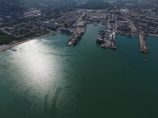 Obraz premium Port morski przemysłowy, widok z góry. Dźwigi portowe, statki towarowe i barki.
