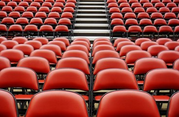 Naklejka premium Folded red seats at a multipurpose arena and sports stadium