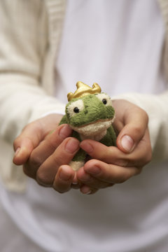 Girls hands holding stuffed frog