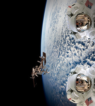 Planet Earth two astronauts spaceman helmet suit outer spacewalk international space station. Elements of this image furnished by NASA.