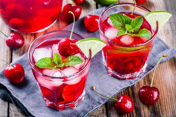 cherry lemonade with ice, lime and mint in glasses