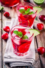 cherry lemonade with ice, lime and mint in glasses