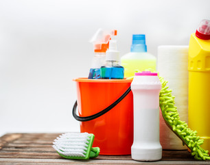 Bucket with cleaning items on light background