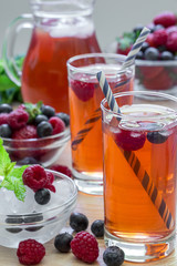 Compote of raspberries, strawberries and blueberries with straws.